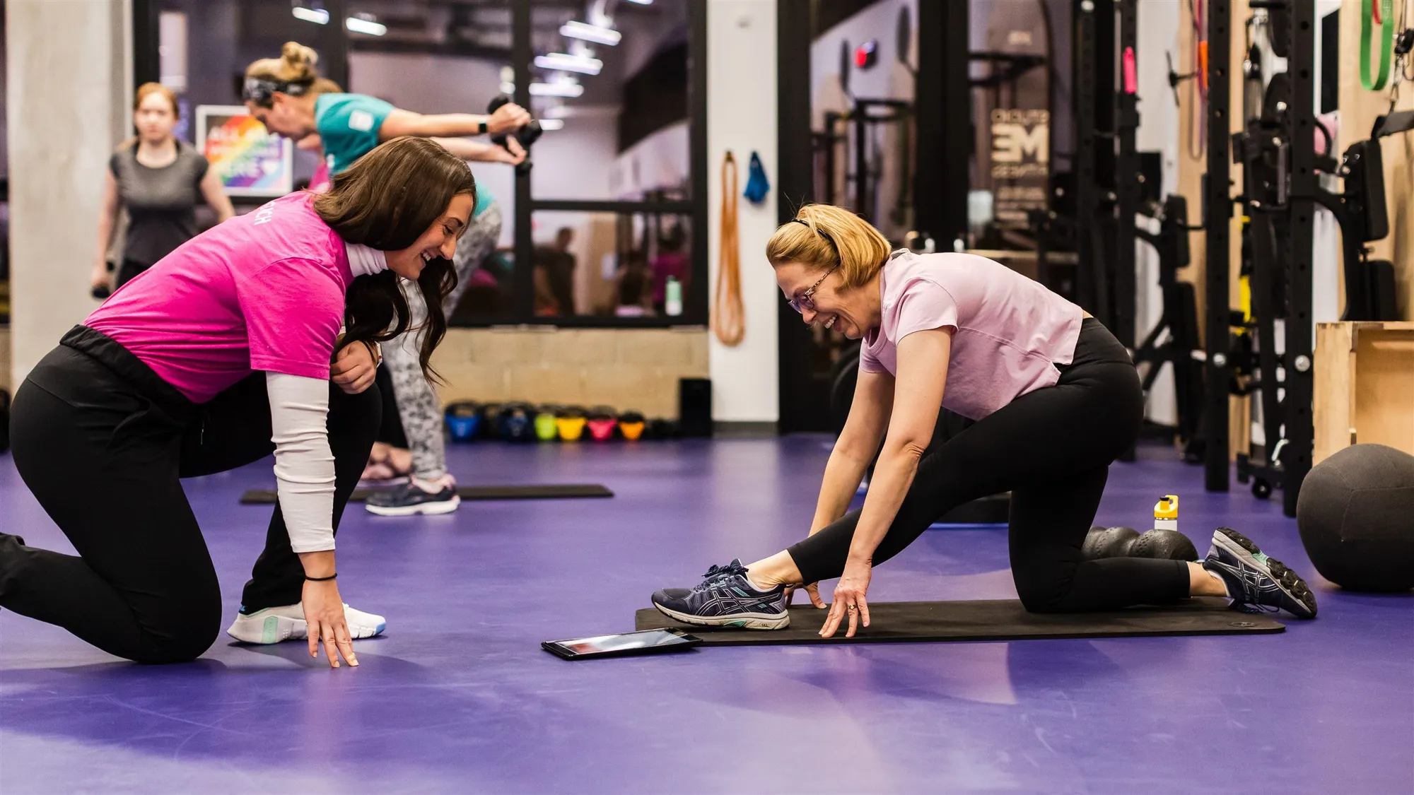 Coach instructing members during a semi-private personal training session at Studio ME Fitness in Northeast Minneapolis, each working on their own custom strength program.