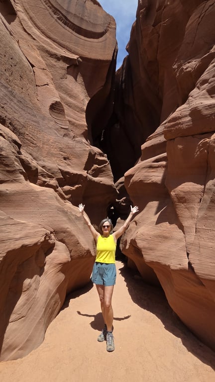 Studio ME member Susie hiking through a red rock canyon during a solo adventure after building strength and confidence through fitness.